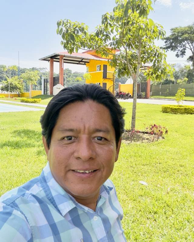 Oscar Reynoso en la entrada de Buenaventura San Alberto, con la garita y las áreas verdes al fondo