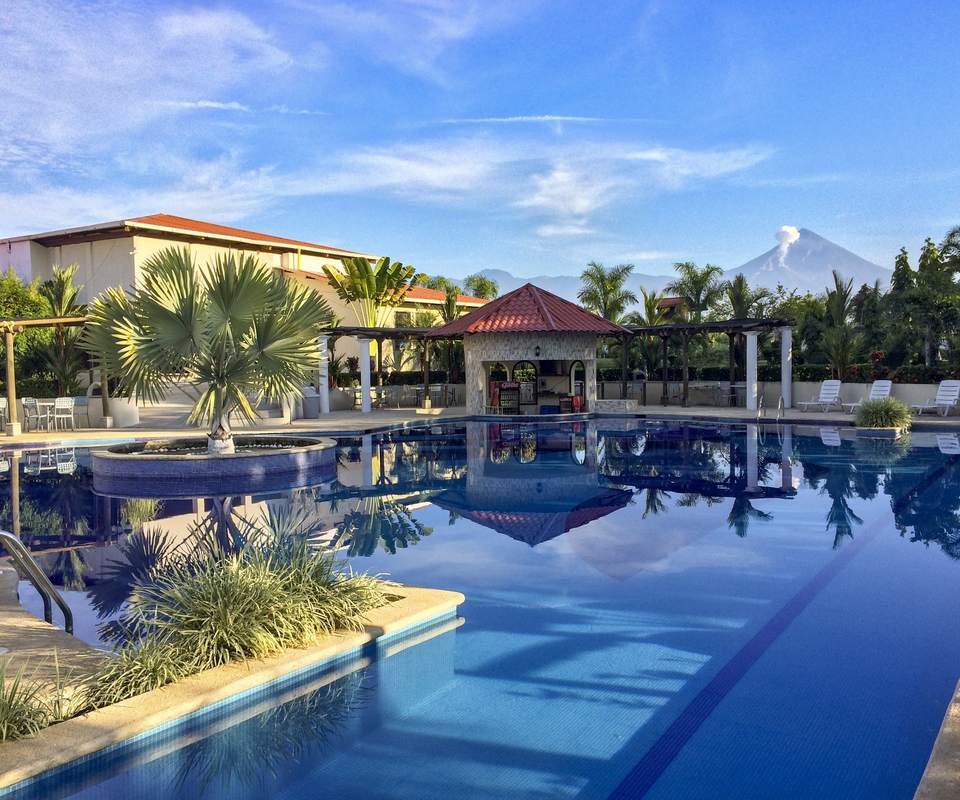 Piscina, kiosco y casa club de un proyecto entregado, con un volcán al fondo