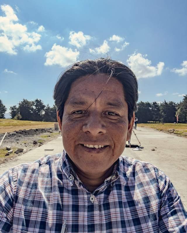 Oscar Reynoso en Buenaventura Tecpán, sobre una calle nueva de concreto rodeada de cipreses
