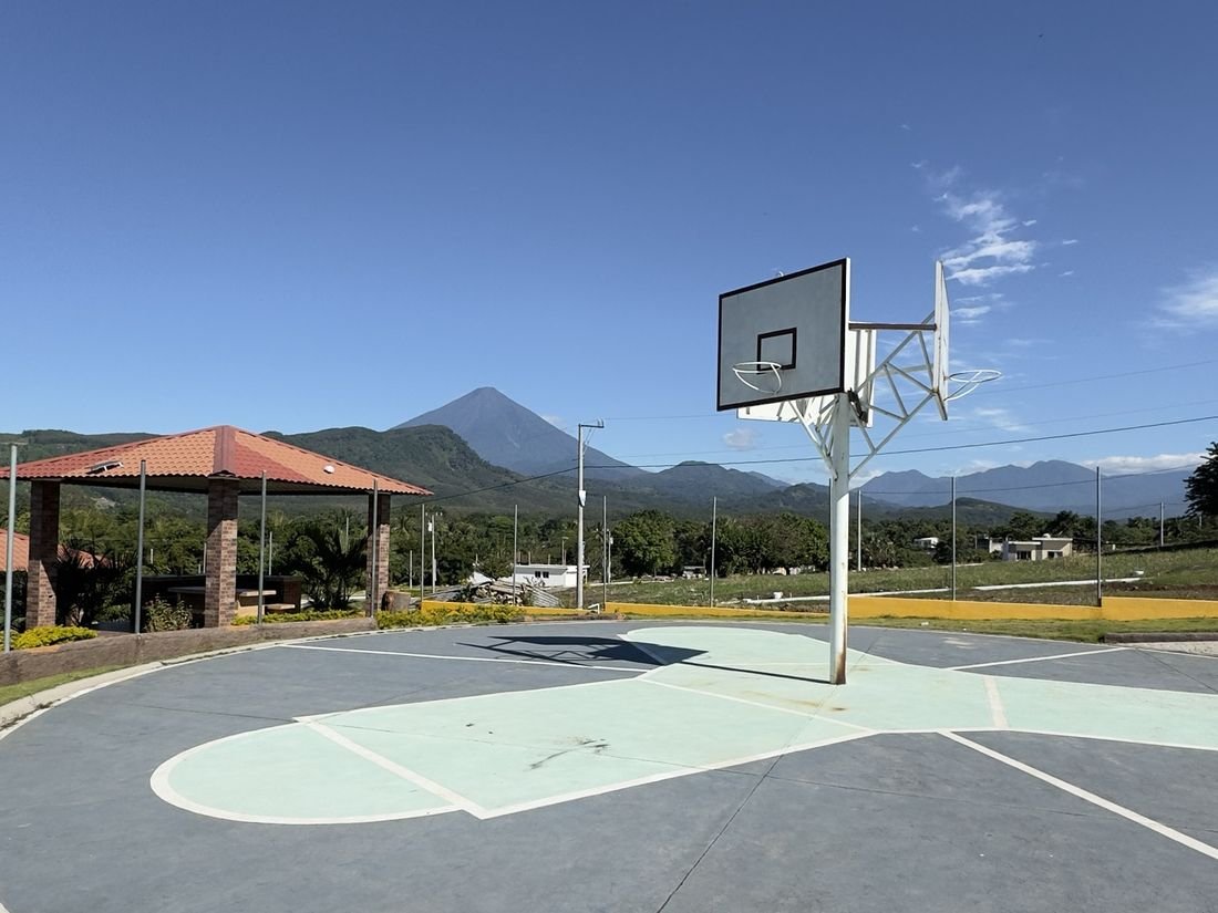 Cancha polideportiva de Buenaventura Patulul con un volcán al fondo