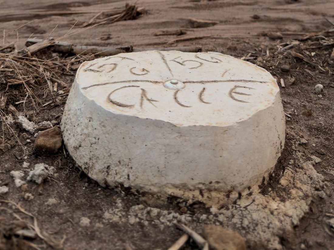 Mojón de concreto marcando el lindero de un lote y el trazo de la calle